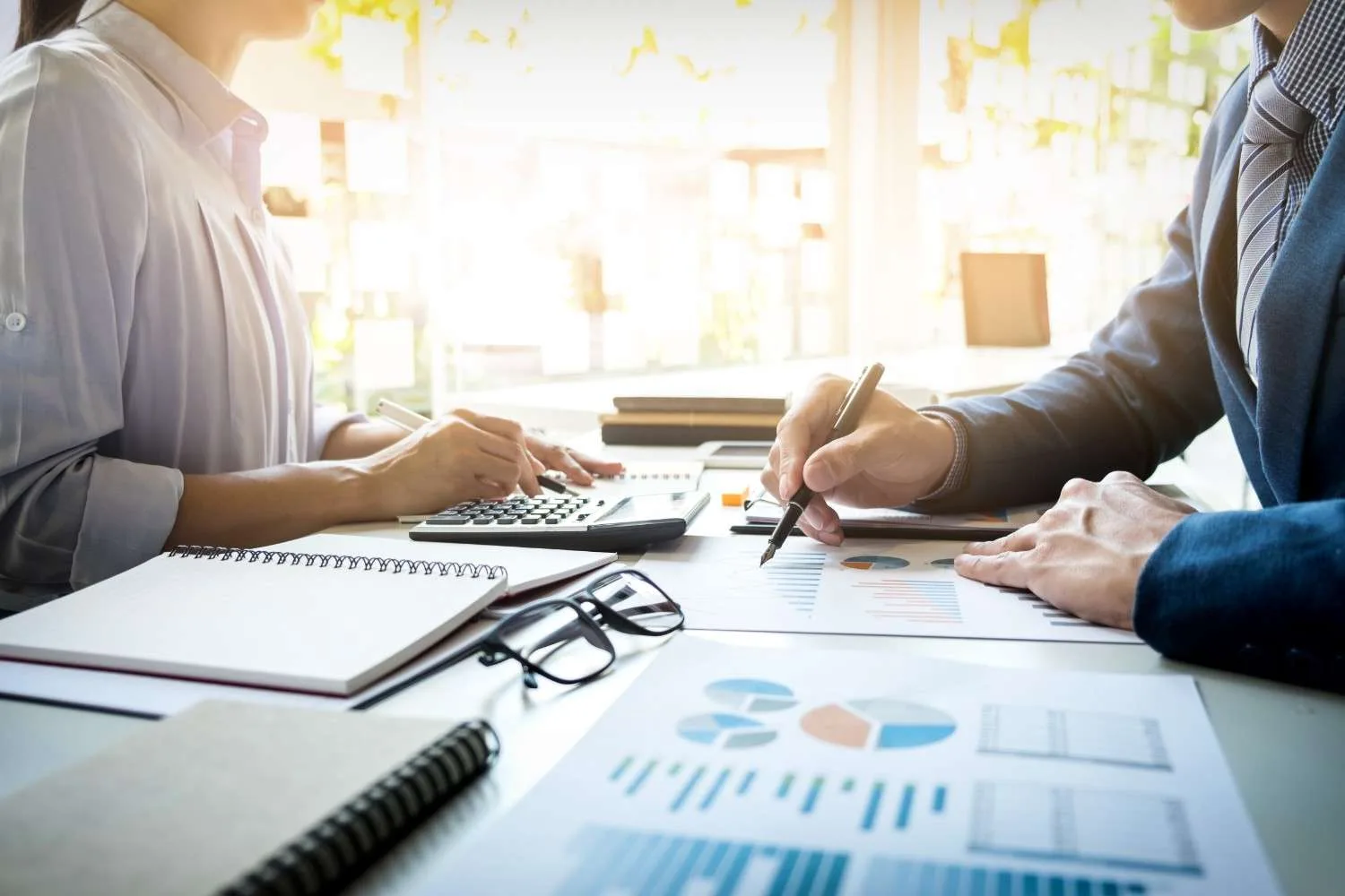 Two professionals reviewing financial charts and documents
